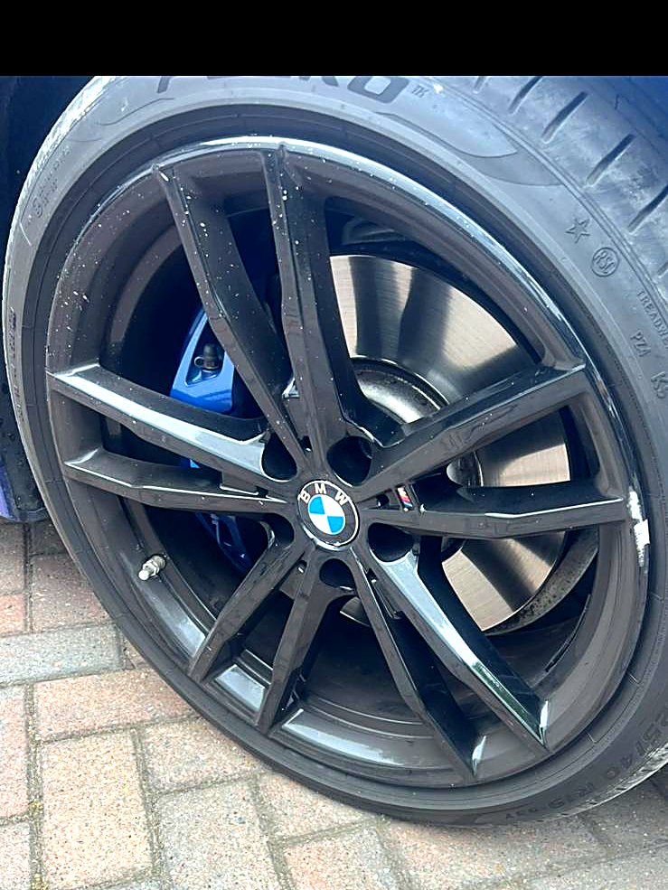 Blue BMW 3 Series with a gloss black refinished double-spoke alloy wheel