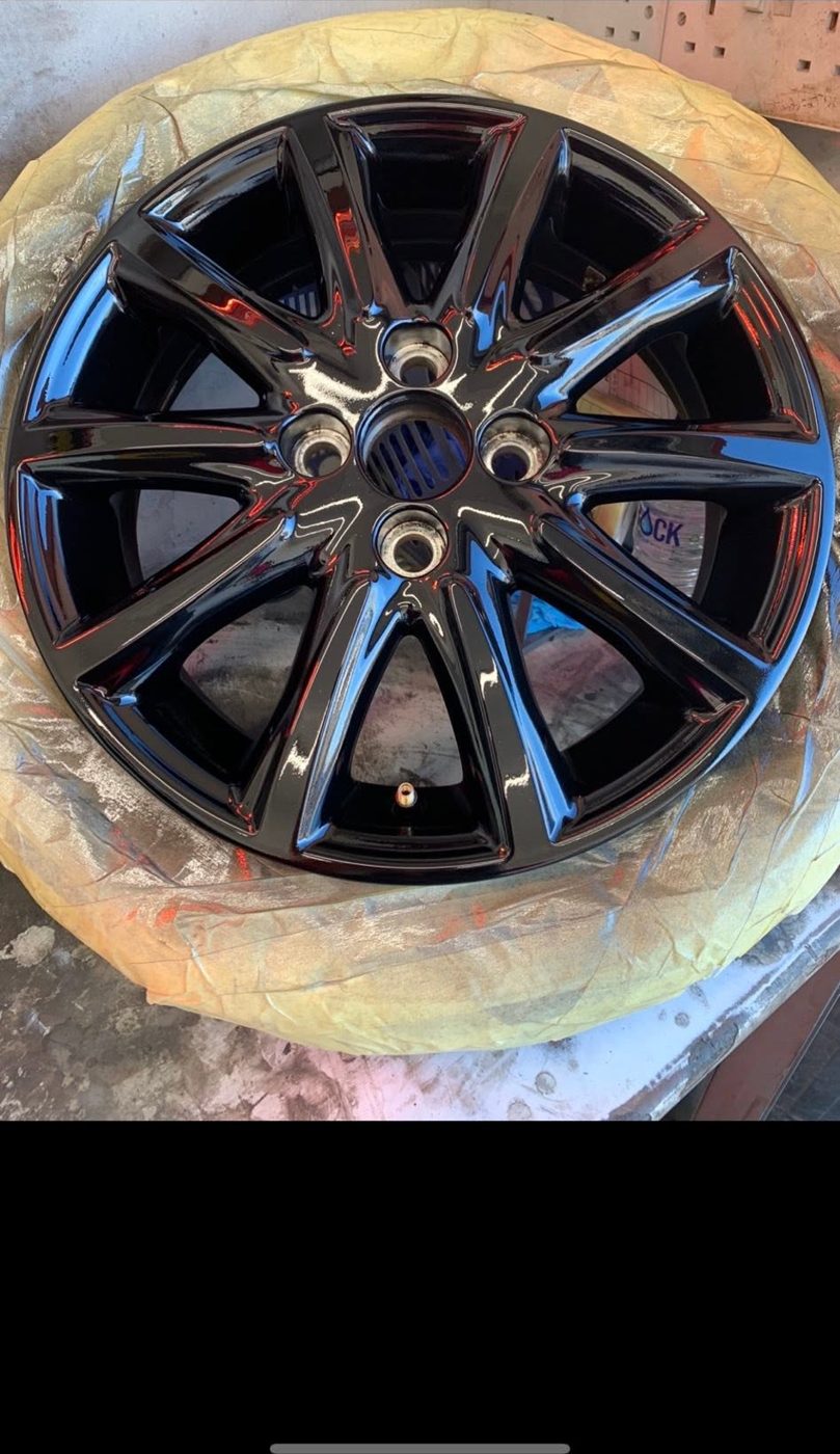 Freshly gloss black refinished alloy wheel in the workshop