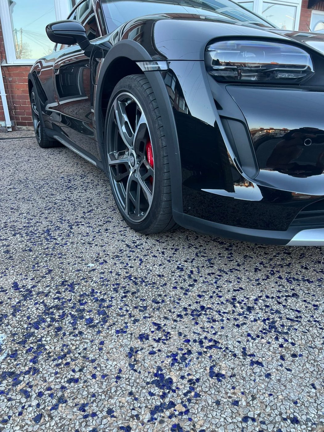 Black Porsche Taycan with refurbished graphite alloy wheels