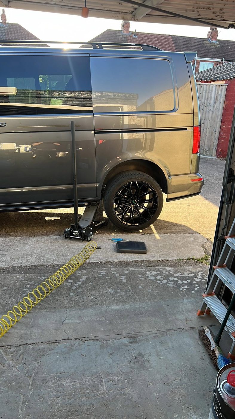 Grey VW Transporter having gloss black alloys fitted on the driveway